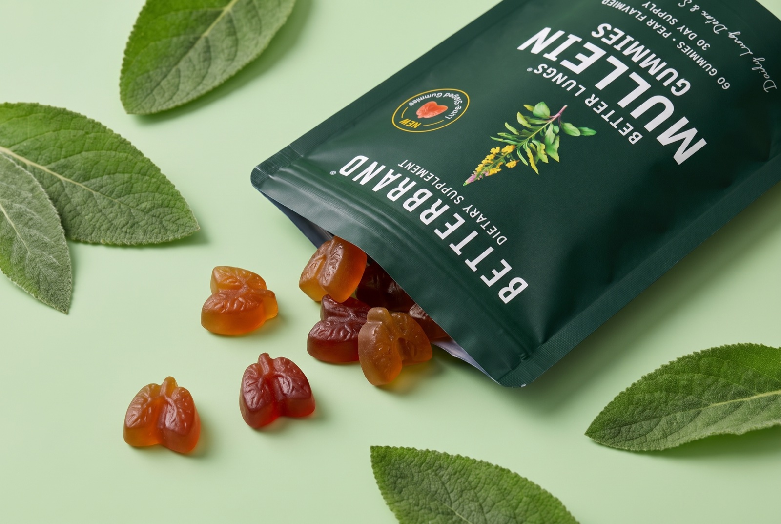 A pouch of BetterLungs Mullein Gummies with the lung-shaped pear gummies spilled beside it and a mullein sprig